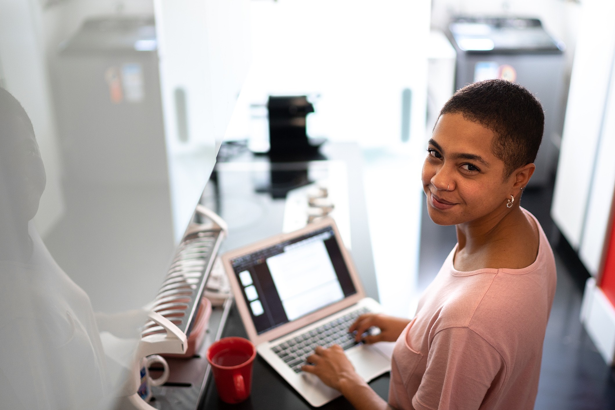 Mulher olhando a tela de um computador e pesquisando sobre novas profissões.